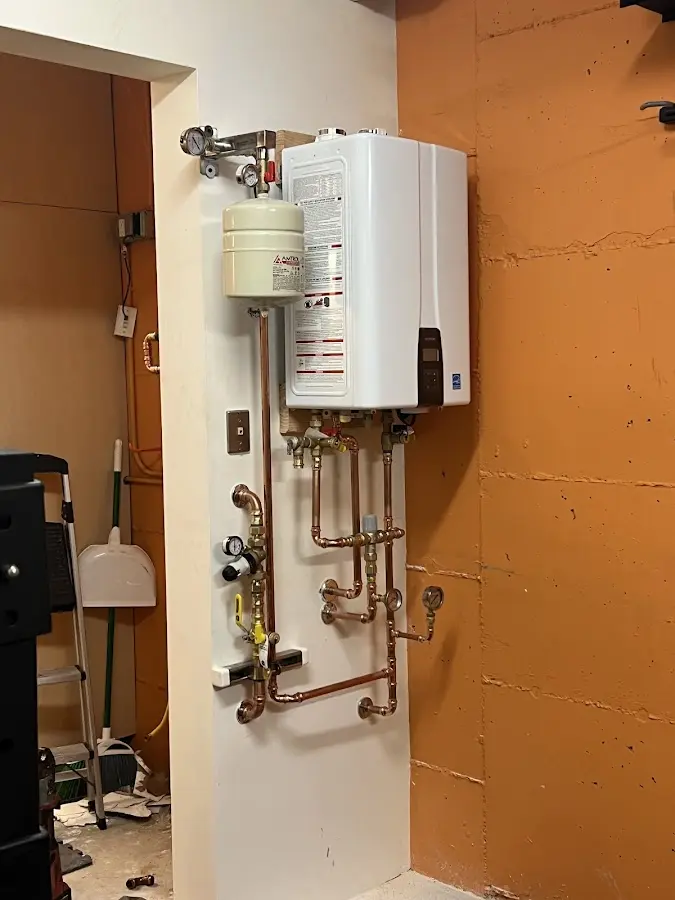 Plumbing technician inspecting water heater connections in Winterville